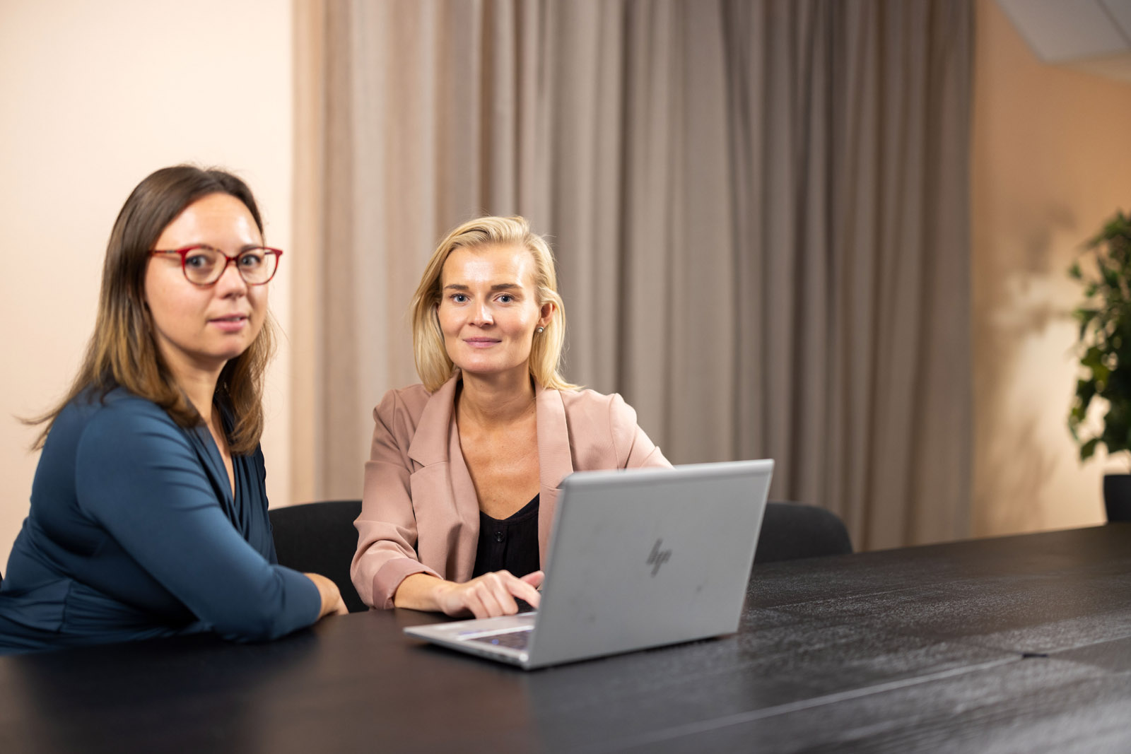 Två personer som tittar in i kameran och läser beslutsbarometern av VIEW Group på laptop framför dem.